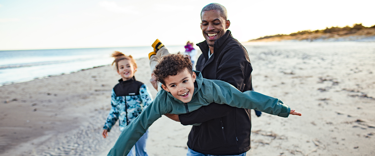 Young kids playing outside with their parent.