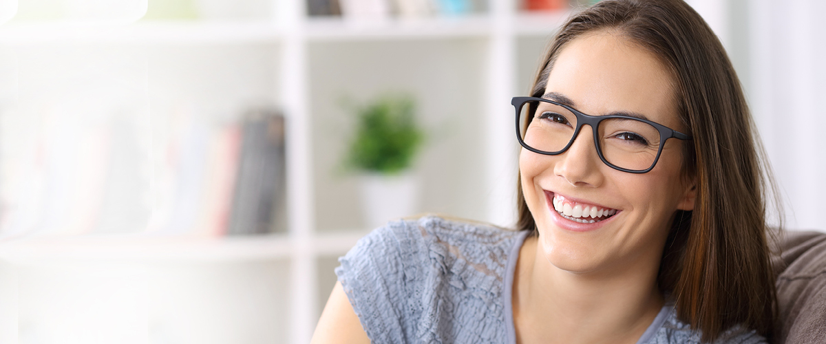 Woman wearing glasses and smiling.