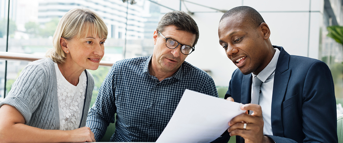Three people reading a document.