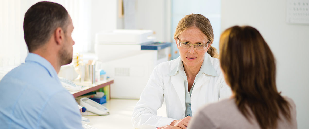A couple speaking with a physician in a medical office.