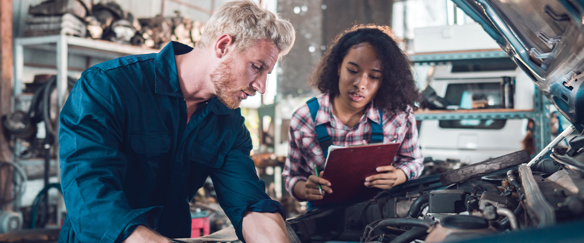 2 car mechanics working on vehicle